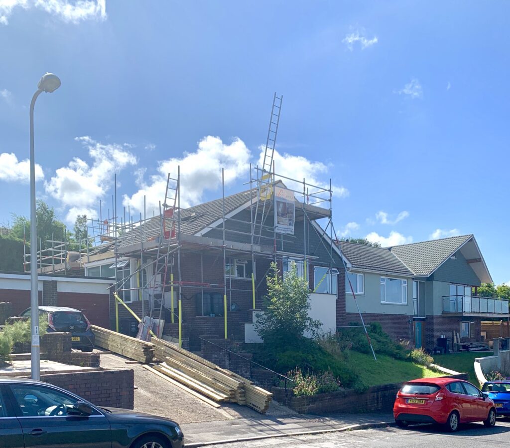 Street view of a bungalow being raised to two storeys, scaffolding in place