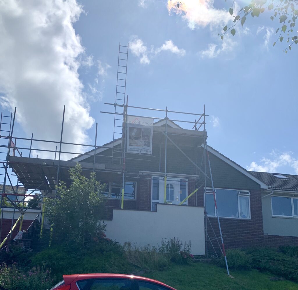 Bungalow behind scaffolding during conversion to a two-storey house