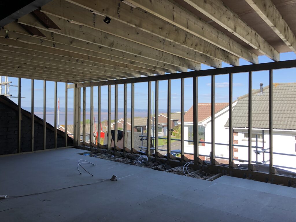 Structural opening formed across a full elevation, steel columns supporting the floor above