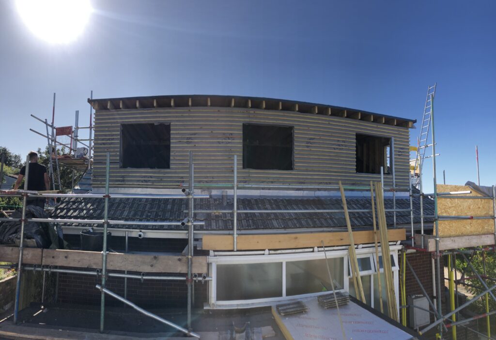 Blockwork upper storey under construction behind scaffolding