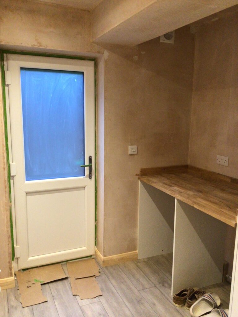 Newly built utility space in a converted garage, freshly plastered with worktop and units being fitted