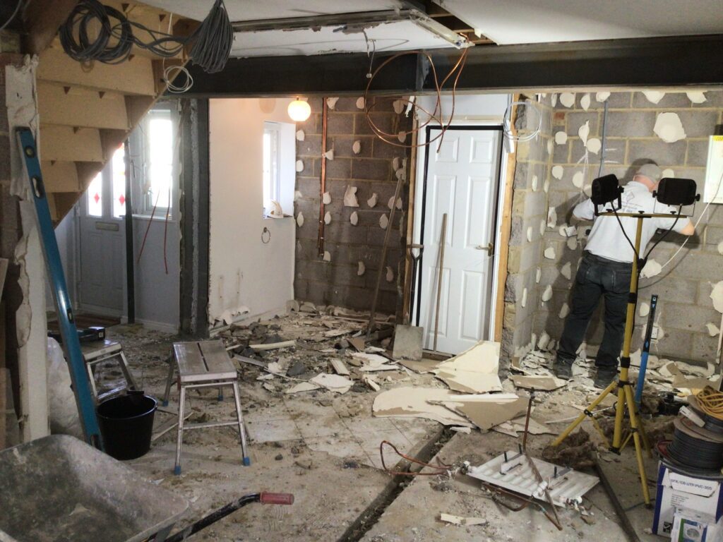 Garage stripped back to blockwork during conversion, steel beam installed and first-fix electrics under way