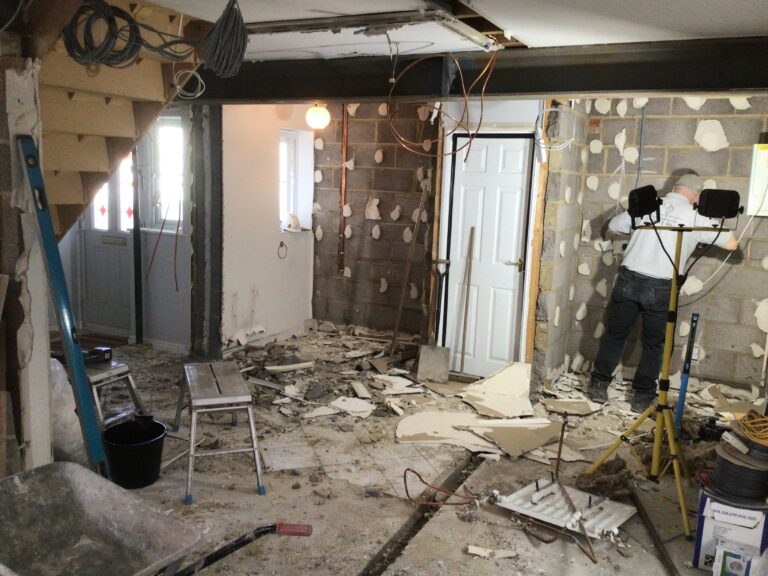 Garage stripped back to blockwork during conversion, steel beam installed and first-fix electrics under way