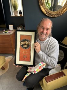 Member of the Excellence Living team holding a framed print
