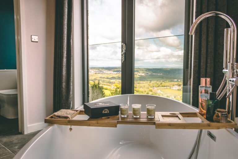Loft bedroom with a bath beside the window and a countryside view