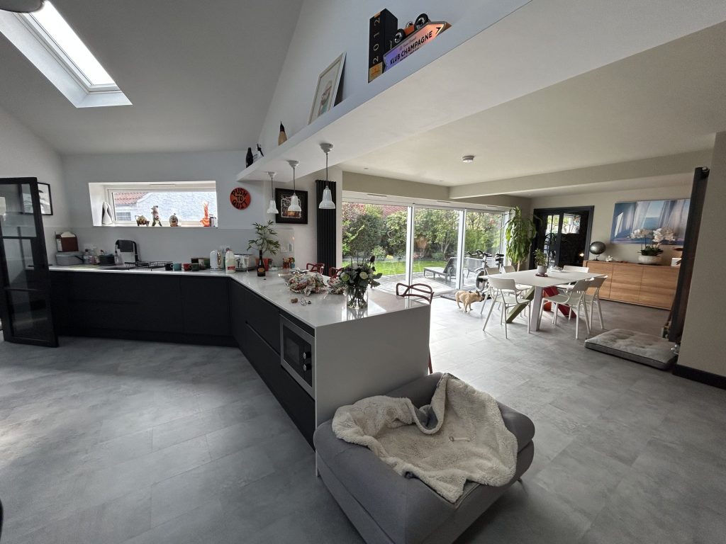 Open-plan kitchen extension with a dark island and full-width garden glazing