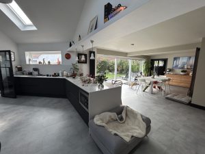 Open-plan kitchen extension with a dark island and full-width garden glazing