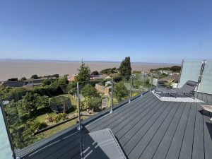 Roof terrace with glass balustrade and decking overlooking the estuary