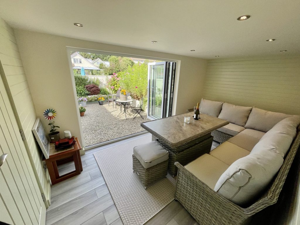 Garage conversion opening onto a courtyard garden through bifold doors