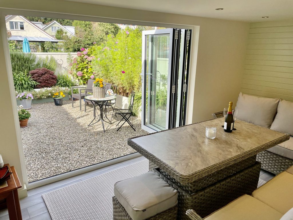 Converted garage dining area looking out to a gravelled garden through bifold doors