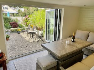Converted garage dining area looking out to a gravelled garden through bifold doors