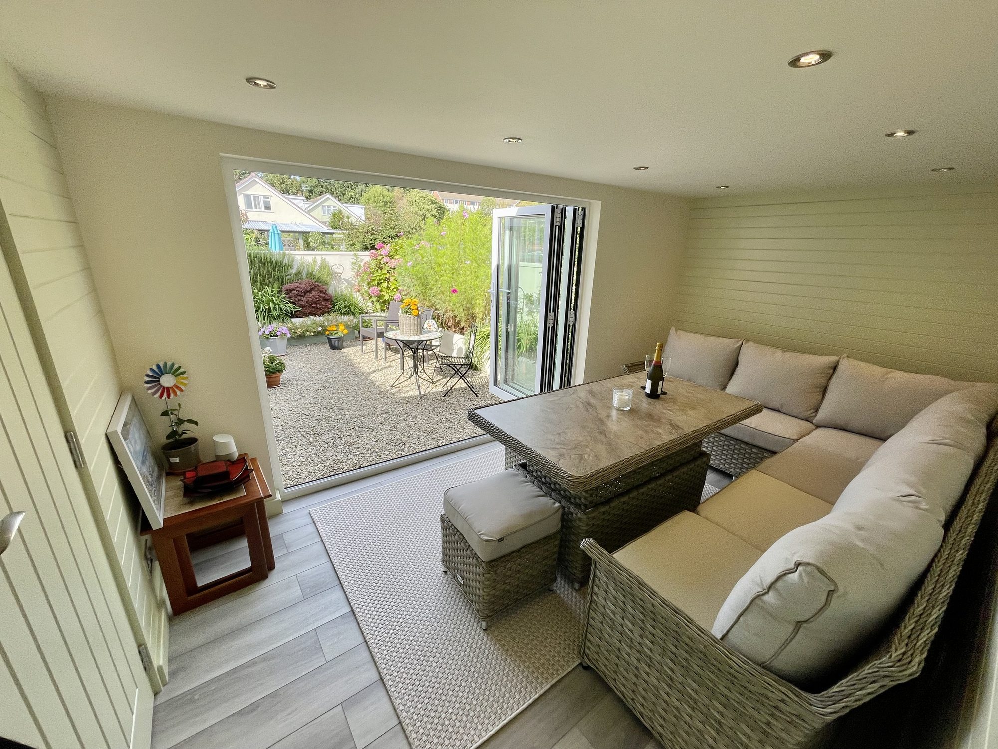 Converted garage used as a garden room, with bifold doors onto a gravelled courtyard