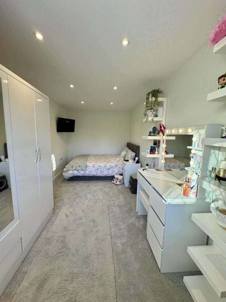 Converted garage fitted out as a bedroom with wall-to-wall wardrobes