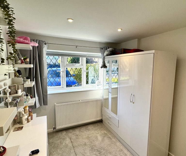 Converted garage in use as a dressing room, with fitted wardrobes and a window seat