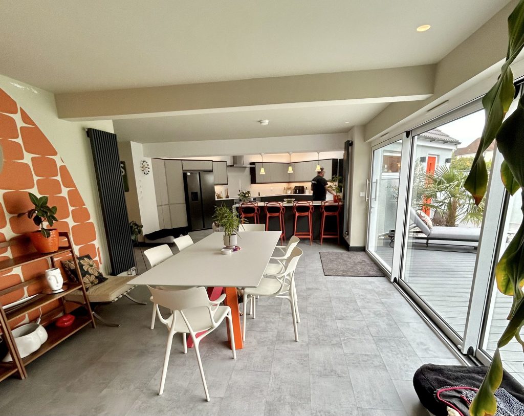 Kitchen dining area with an exposed brick feature wall and bifold doors to a courtyard
