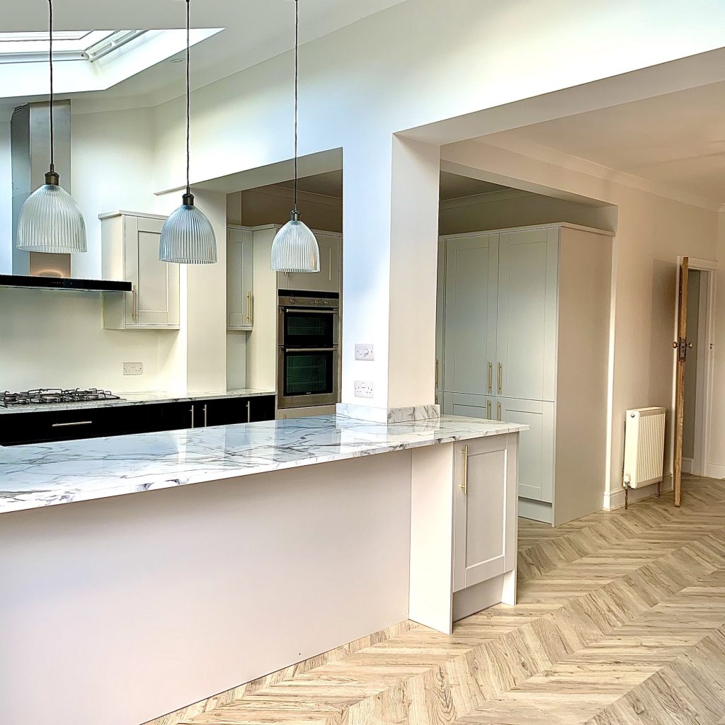 Kitchen with marble-effect worktops, a breakfast bar and integrated ovens