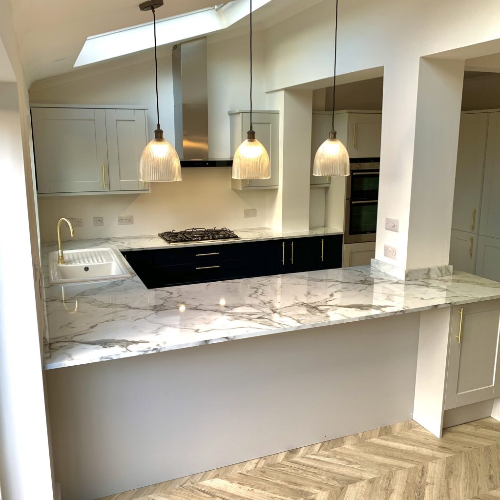 Kitchen with marble-effect worktops, gas hob and pendant lighting