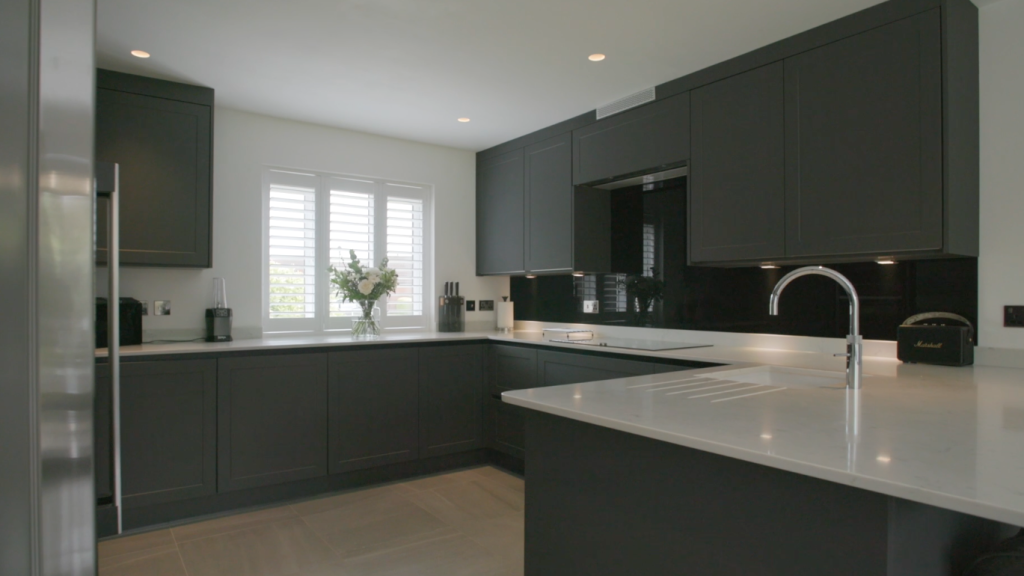 Grey kitchen with a large island and a window above the sink