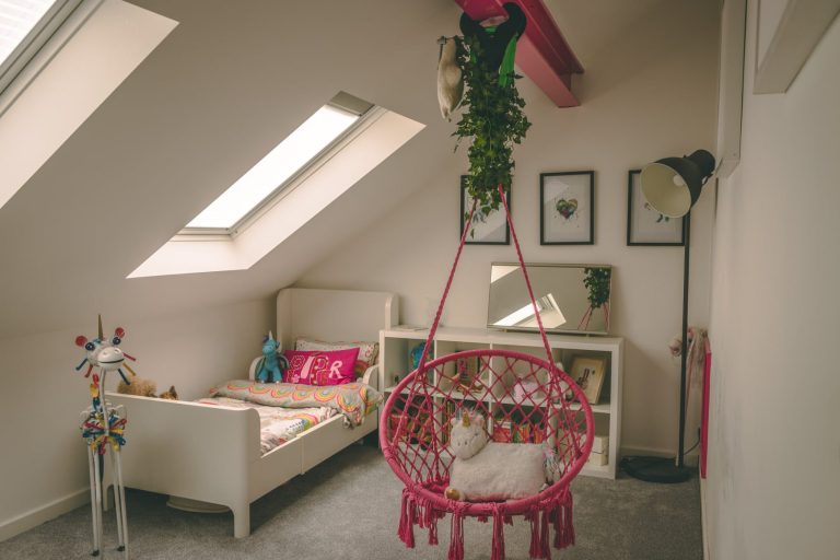 Child's loft bedroom with a Velux roof window, hanging chair and painted day bed