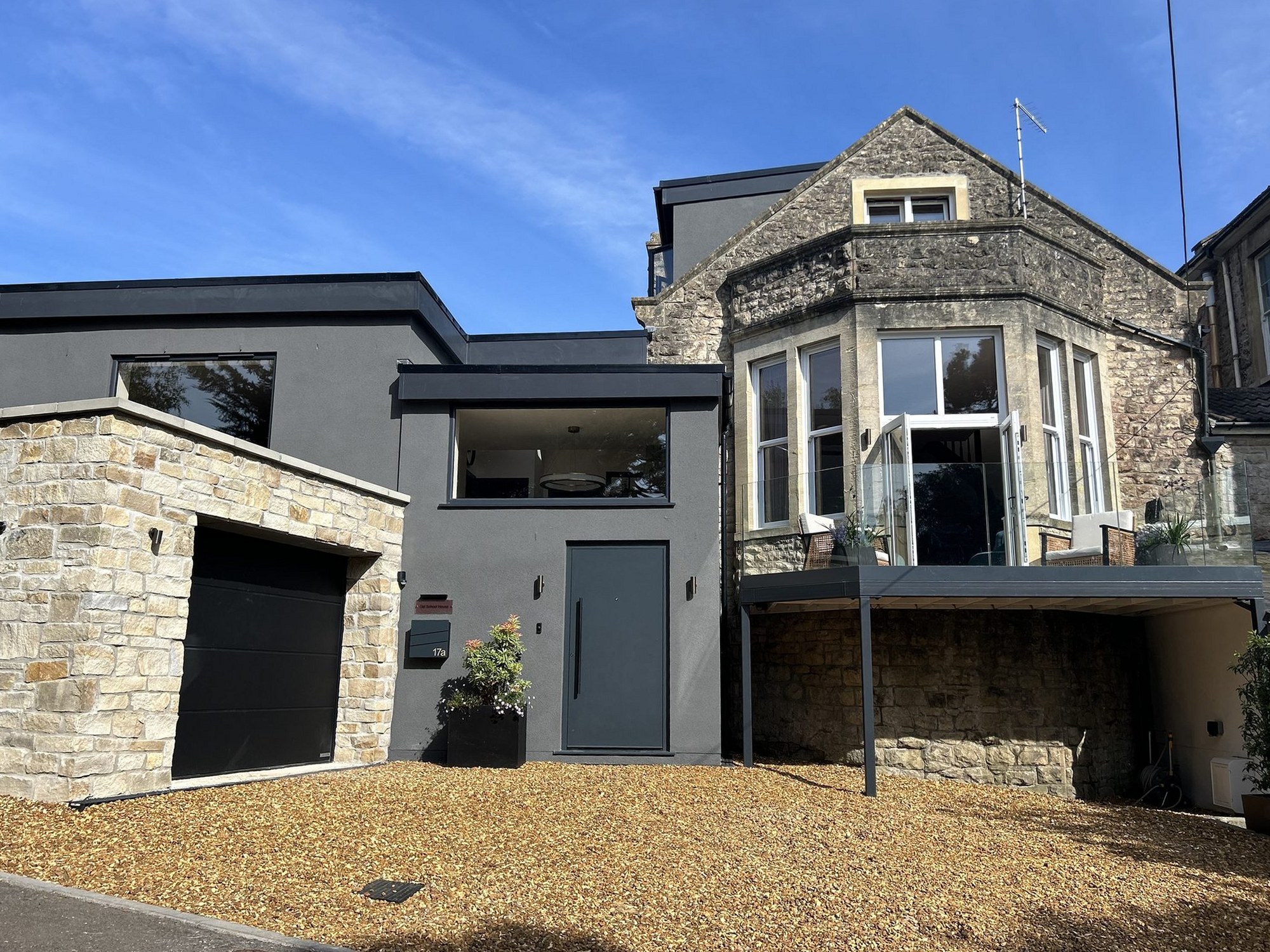 Period stone house with a contemporary rendered extension and integral garage